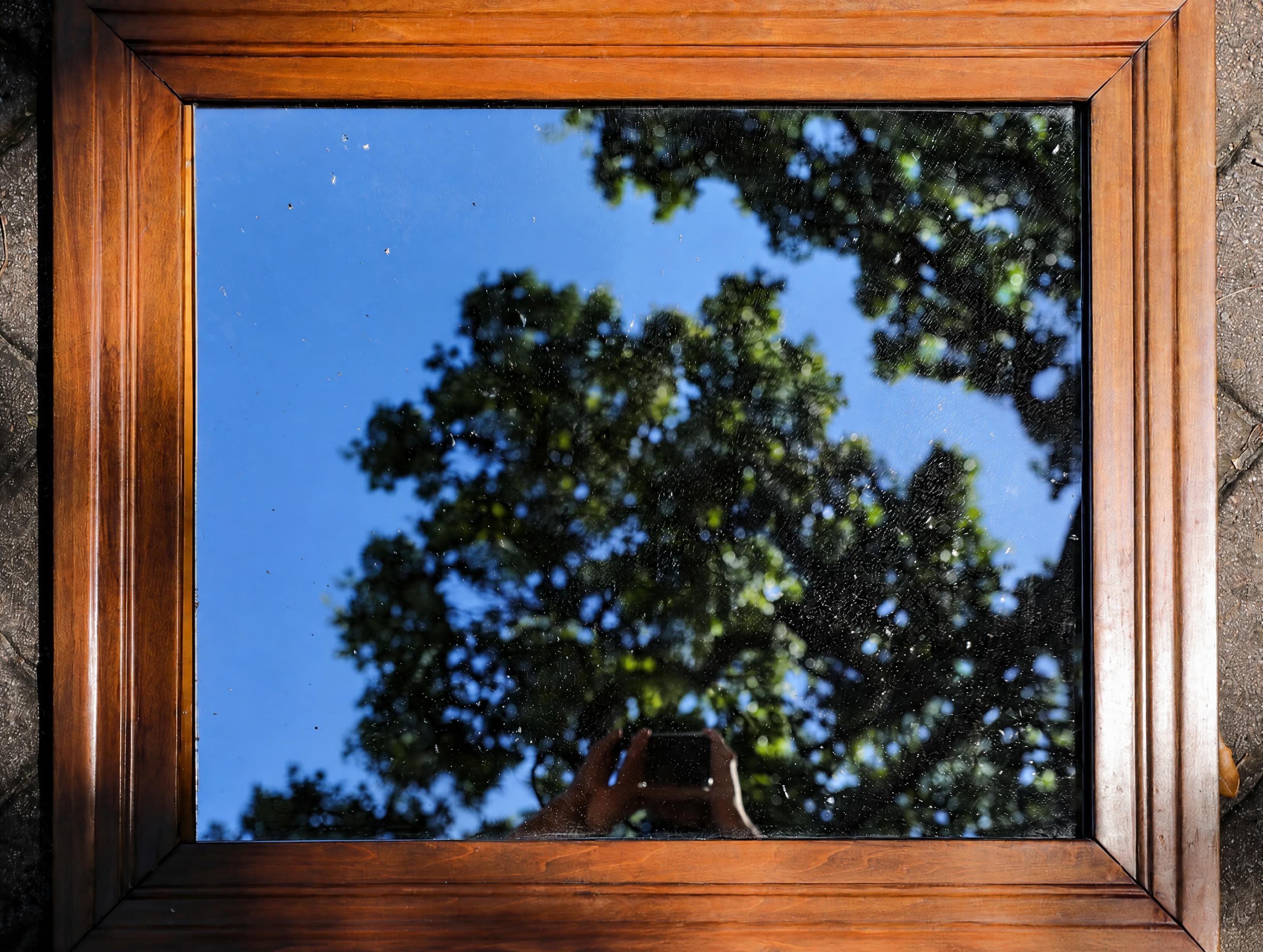 Reference fidelity test result: GPT Images 2.5 repaired the cracked glass while keeping the reflected sky and trees unchanged